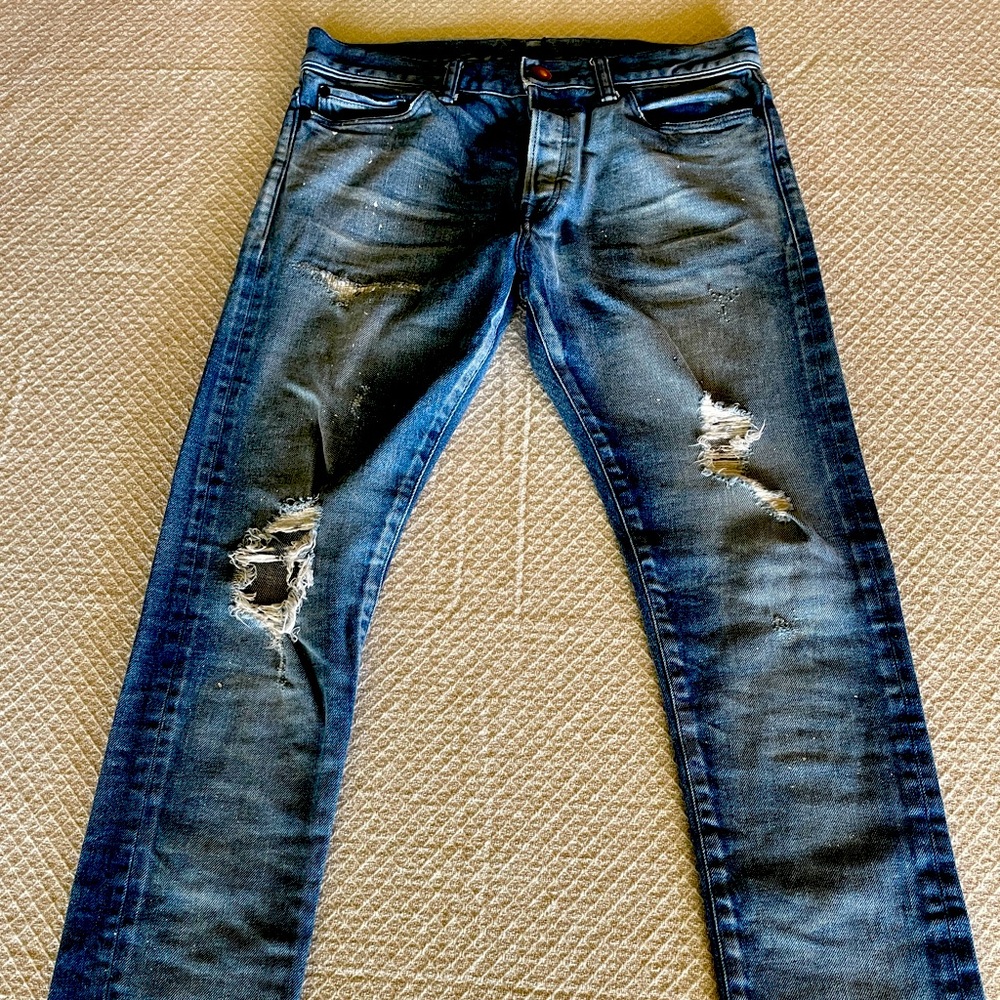NWOT John Elliott men’s distressed and paint splatter slim jeans.